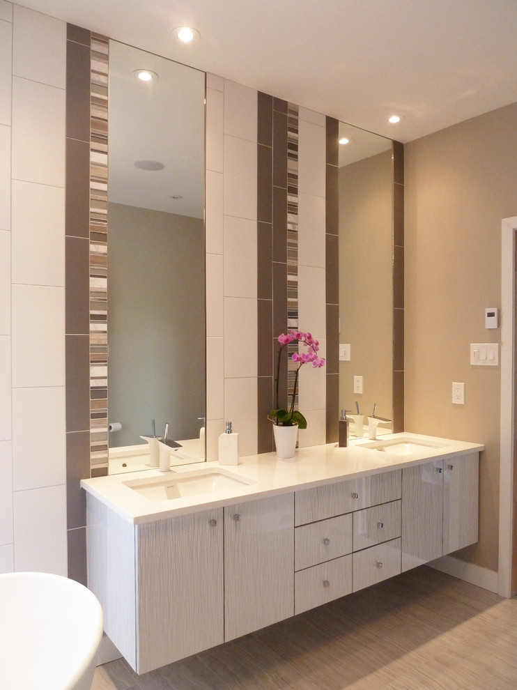 Inspiration for a contemporary bathroom in Ottawa with a submerged sink, flat-panel cabinets, grey cabinets, a freestanding bath, multi-coloured tiles and beige walls.