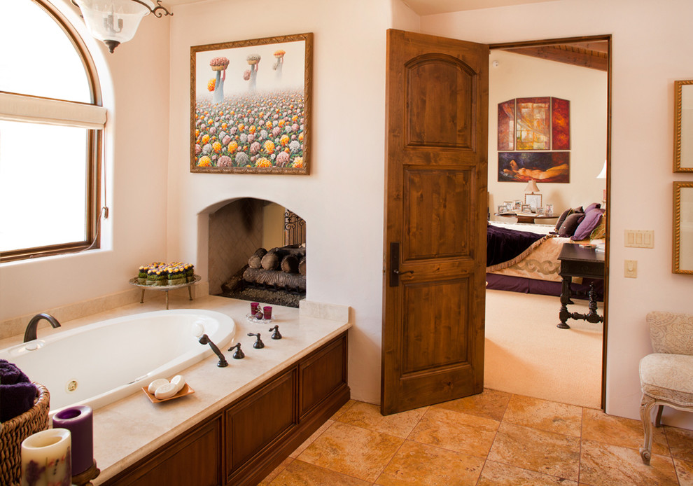 Exemple d'une salle de bain principale sud-ouest américain en bois foncé avec un placard avec porte à panneau surélevé, une baignoire encastrée, un mur blanc et un sol en carrelage de céramique.