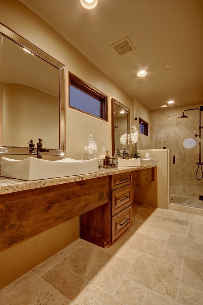 Inspiration pour une salle de bain sud-ouest américain en bois foncé de taille moyenne avec un placard avec porte à panneau surélevé, WC à poser, un carrelage beige, un carrelage de pierre, un mur beige, un sol en travertin, un lavabo encastré et un plan de toilette en granite.