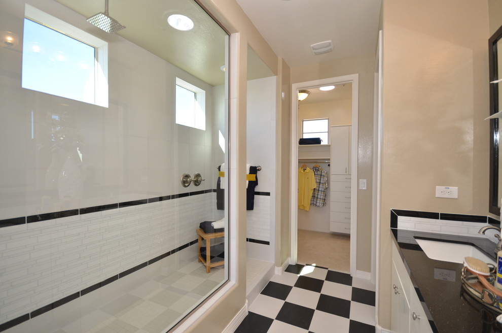 This is an example of a medium sized modern ensuite bathroom in Phoenix with a submerged sink, flat-panel cabinets, white cabinets, engineered stone worktops, an alcove shower, a one-piece toilet, white tiles, metro tiles, beige walls and porcelain flooring.