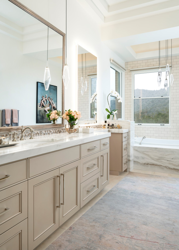 Klassisk inredning av ett flerfärgad flerfärgat en-suite badrum, med luckor med infälld panel, beige skåp, ett platsbyggt badkar, vit kakel, tunnelbanekakel, vita väggar, ett undermonterad handfat och beiget golv