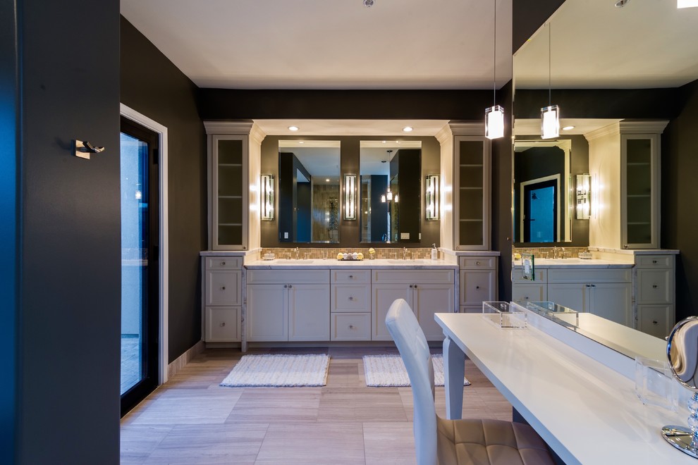 Design ideas for an expansive traditional ensuite bathroom in Phoenix with raised-panel cabinets, white cabinets, a freestanding bath, a double shower, a one-piece toilet, grey tiles, stone tiles, grey walls, limestone flooring, a built-in sink, quartz worktops, beige floors and a hinged door.