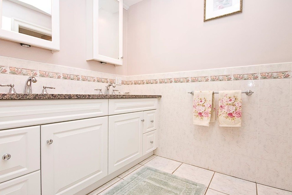 This is an example of a large classic bathroom in Boston with raised-panel cabinets, white cabinets, marble worktops, a one-piece toilet, ceramic tiles, pink walls and ceramic flooring.