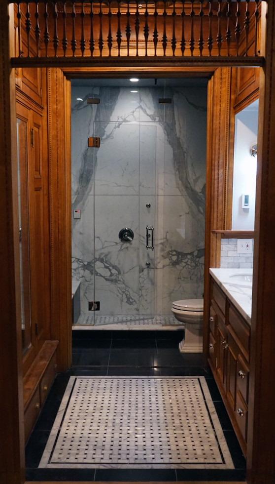 Photo of a medium sized contemporary shower room bathroom in New York with recessed-panel cabinets, dark wood cabinets, a corner shower, a one-piece toilet, beige tiles, grey tiles, white tiles, stone slabs, black walls, porcelain flooring and marble worktops.