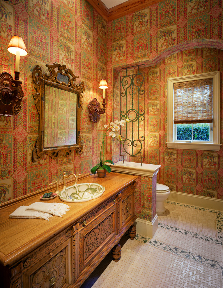 Inredning av ett medelhavsstil mellanstort badrum med dusch, med luckor med infälld panel, bruna skåp, en toalettstol med separat cisternkåpa, flerfärgade väggar, klinkergolv i keramik, ett nedsänkt handfat och träbänkskiva