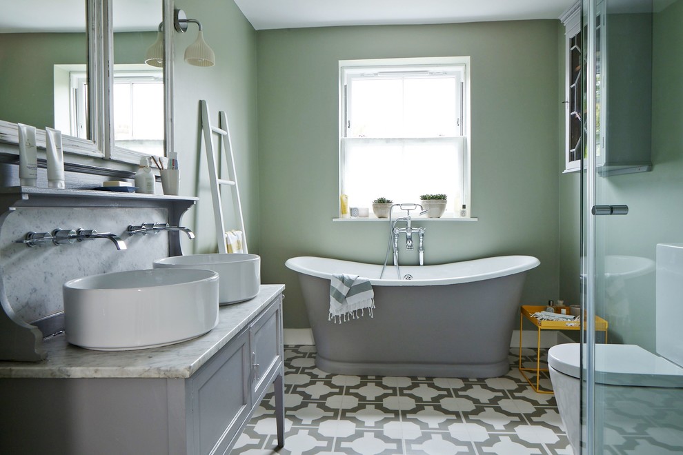Classic ensuite bathroom in London with a vessel sink, recessed-panel cabinets, grey cabinets, a freestanding bath, a two-piece toilet, white tiles and green walls.