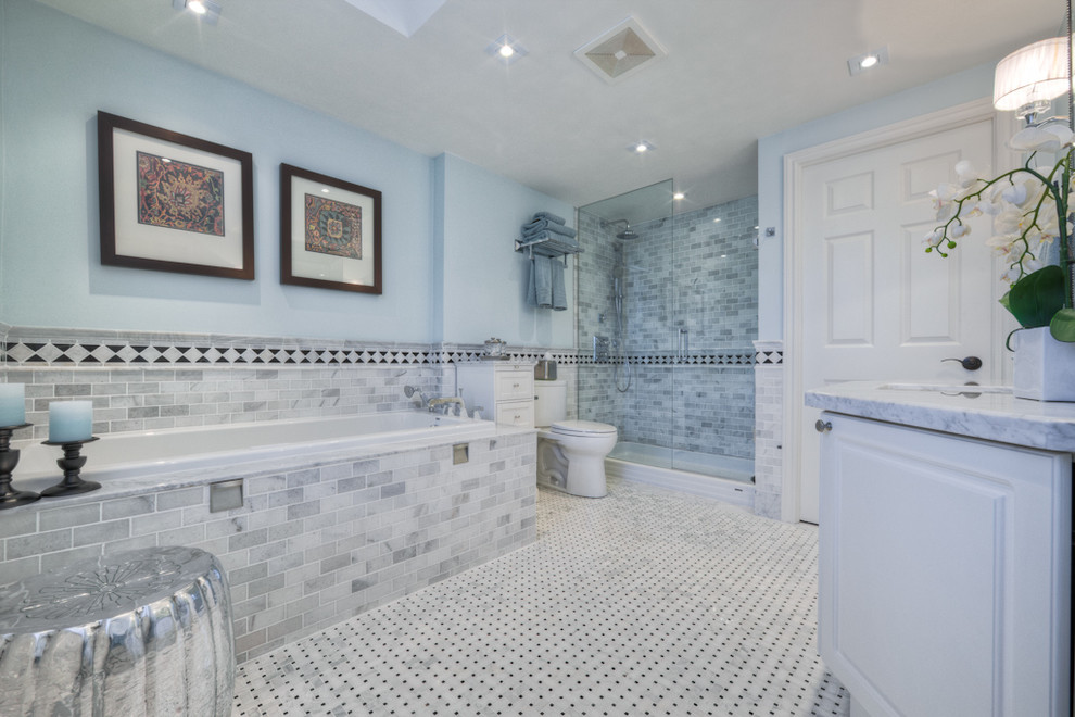 Пример оригинального дизайна: главная ванная комната среднего размера в стиле неоклассика (современная классика) с врезной раковиной, фасадами с выступающей филенкой, мраморной столешницей, душем в нише, раздельным унитазом, серой плиткой, плиткой кабанчик, синими стенами, мраморным полом и накладной ванной