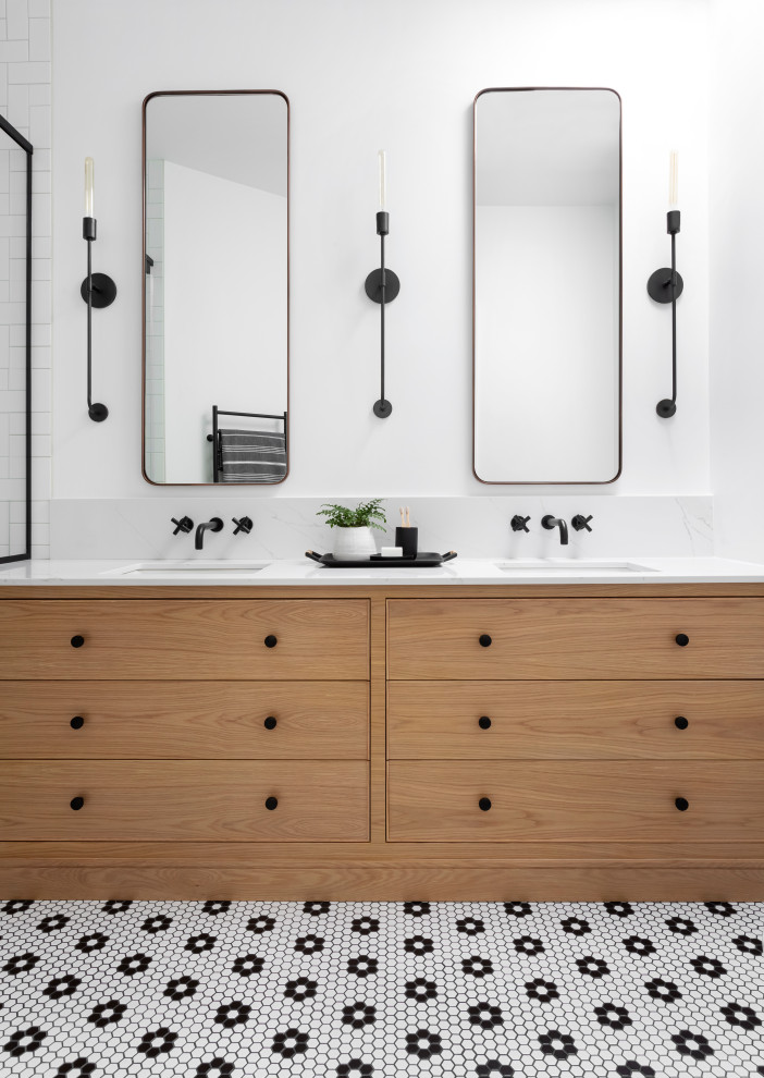This is an example of a medium sized scandinavian family bathroom in Montreal with light wood cabinets, an alcove shower, a one-piece toilet, white tiles, ceramic tiles, white walls, mosaic tile flooring, a submerged sink, engineered stone worktops, black floors, a hinged door, white worktops, a wall niche, double sinks, a built in vanity unit and flat-panel cabinets.