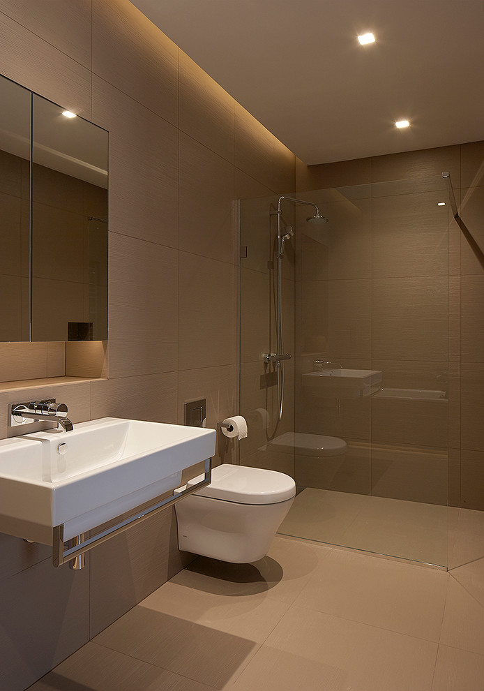На фото: главная ванная комната среднего размера в современном стиле с бежевой плиткой, керамогранитной плиткой, бежевыми стенами, полом из керамогранита и подвесной раковиной с