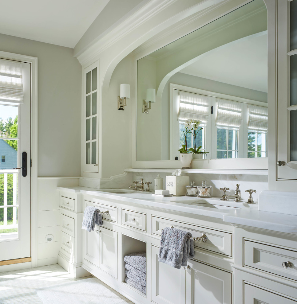 Foto de cuarto de baño principal tradicional con puertas de armario blancas, paredes grises, lavabo bajoencimera, armarios con paneles empotrados, encimera de mármol y encimeras blancas