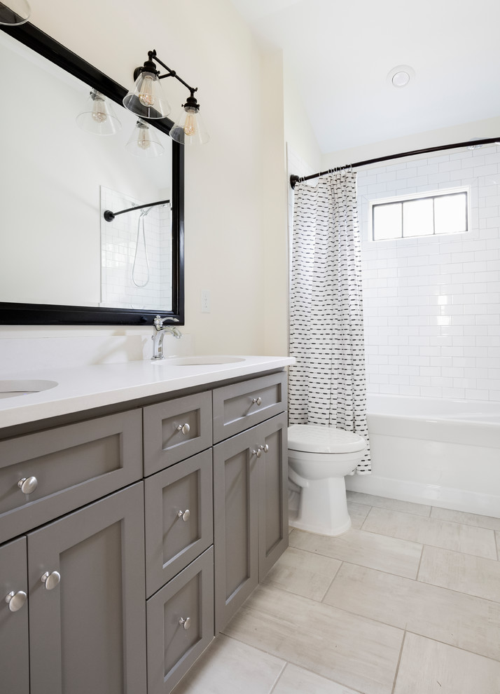 Cette photo montre une salle de bain chic pour enfant avec un placard à porte shaker, des portes de placard grises, un carrelage blanc, un carrelage métro, un mur blanc, un sol en carrelage de céramique, un lavabo encastré, un plan de toilette en quartz modifié, un sol gris, une cabine de douche avec un rideau et un plan de toilette blanc.