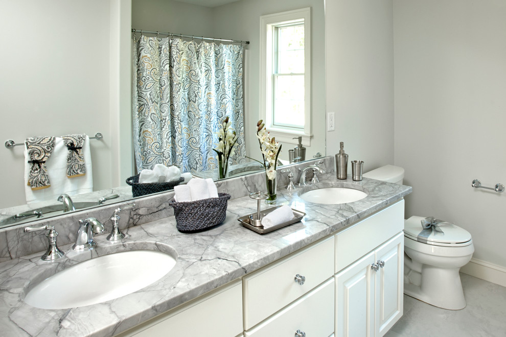 Traditional ensuite bathroom in New York with white cabinets, grey walls, a submerged sink, marble worktops, raised-panel cabinets, an alcove bath and a shower/bath combination.