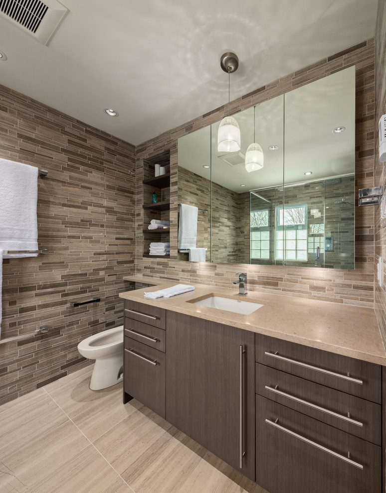 На фото: ванная комната в современном стиле с врезной раковиной, плоскими фасадами, темными деревянными фасадами и коричневой плиткой