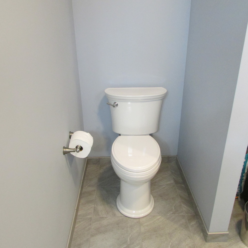 Inspiration för ett stort amerikanskt toalett, med luckor med infälld panel, grå skåp, en toalettstol med separat cisternkåpa, flerfärgad kakel, porslinskakel, blå väggar, klinkergolv i porslin, ett undermonterad handfat, granitbänkskiva och grått golv