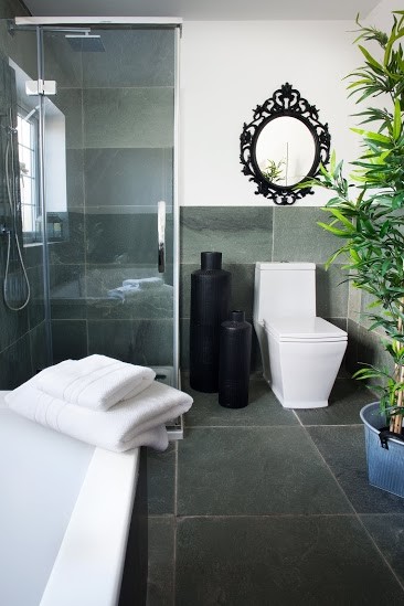 Cette image montre une salle de bain bohème de taille moyenne pour enfant avec une baignoire posée, WC à poser, un sol en ardoise, une douche ouverte, un carrelage vert et un carrelage de pierre.