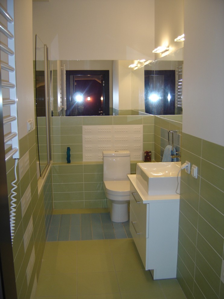 Ejemplo de cuarto de baño contemporáneo pequeño con armarios con paneles lisos, puertas de armario blancas, bañera empotrada, combinación de ducha y bañera, sanitario de dos piezas, paredes verdes, aseo y ducha y lavabo sobreencimera