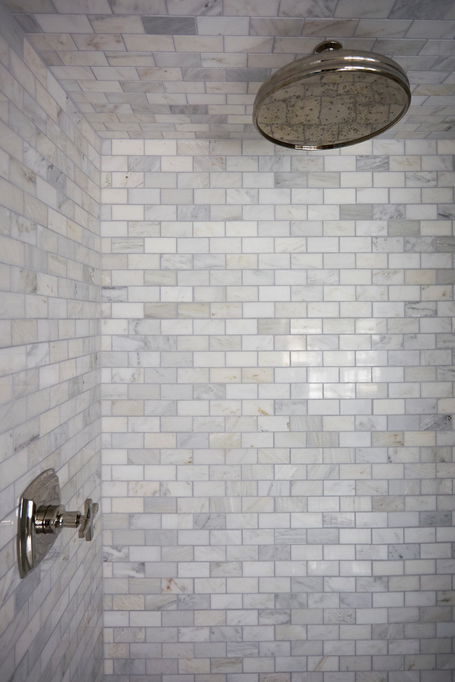 Cette image montre une grande salle de bain principale traditionnelle avec un espace douche bain, un carrelage blanc, du carrelage en marbre, une cabine de douche à porte battante et un mur blanc.