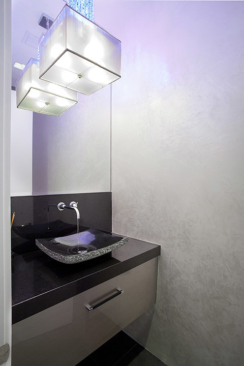 Esempio di una stanza da bagno minimal di medie dimensioni con ante lisce, ante grigie, pareti grigie, lavabo a bacinella, top in superficie solida, pavimento nero e top nero