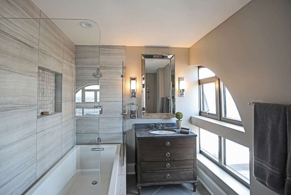 Inredning av ett klassiskt mellanstort grå grått badrum med dusch, med möbel-liknande, skåp i mörkt trä, ett hörnbadkar, en dusch/badkar-kombination, porslinskakel, grå väggar, ett undermonterad handfat, granitbänkskiva och med dusch som är öppen