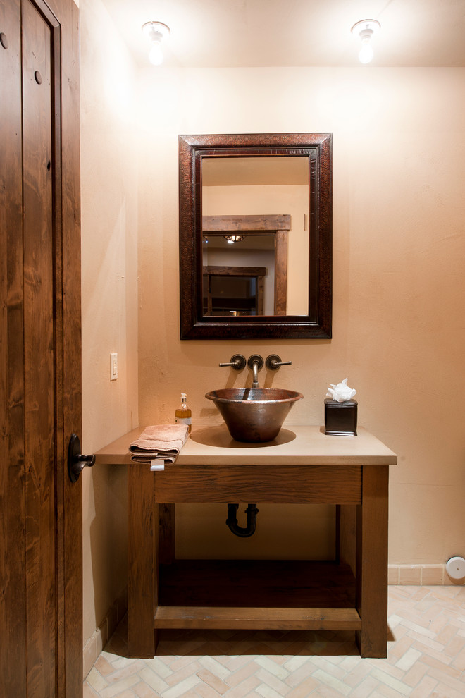 Rustik inredning av ett badrum, med ett fristående handfat och tegelgolv