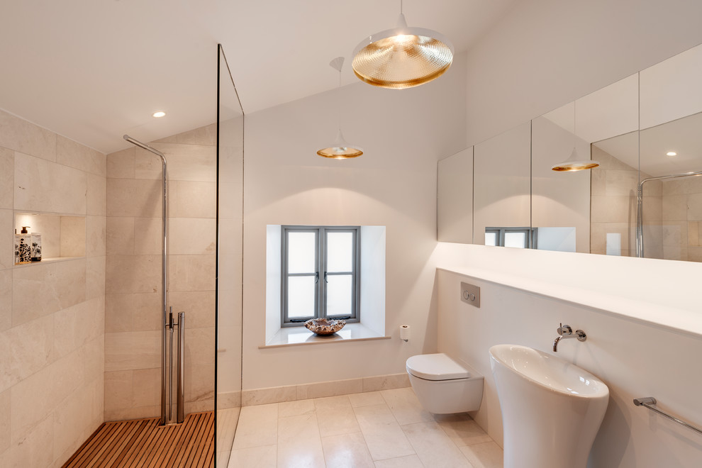 Design ideas for a medium sized contemporary ensuite bathroom in Devon with flat-panel cabinets, white cabinets, a built-in bath, a built-in shower, a wall mounted toilet, white tiles, stone slabs, white walls, marble flooring, a built-in sink, marble worktops, beige floors and an open shower.