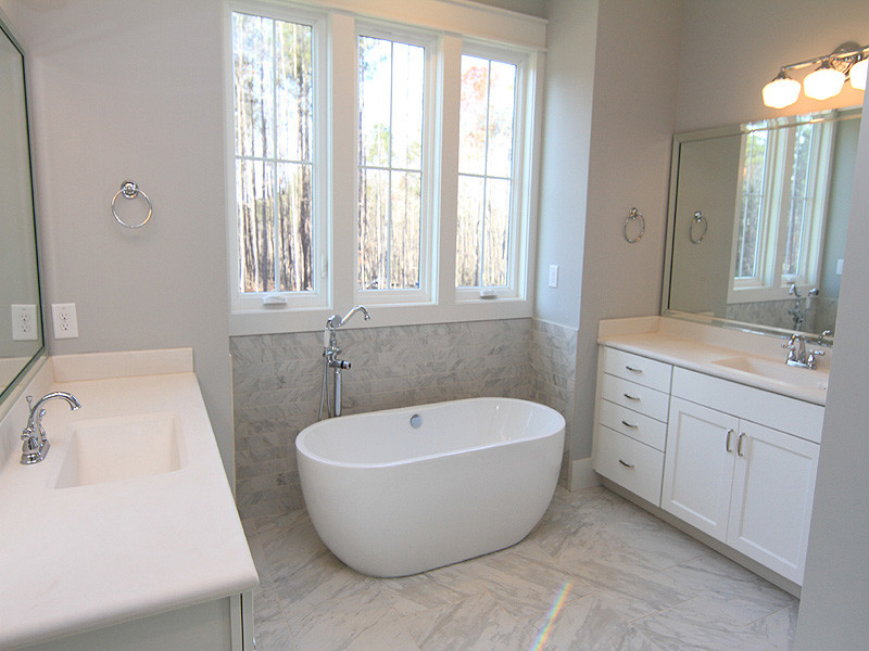 Aménagement d'une salle de bain avec des portes de placard blanches et un mur gris.