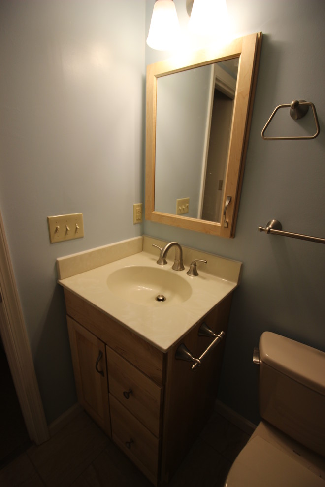 Photo of a small traditional family bathroom in Other with shaker cabinets, light wood cabinets, an alcove bath, a shower/bath combination, a two-piece toilet, beige tiles, porcelain tiles, blue walls, porcelain flooring and an integrated sink.