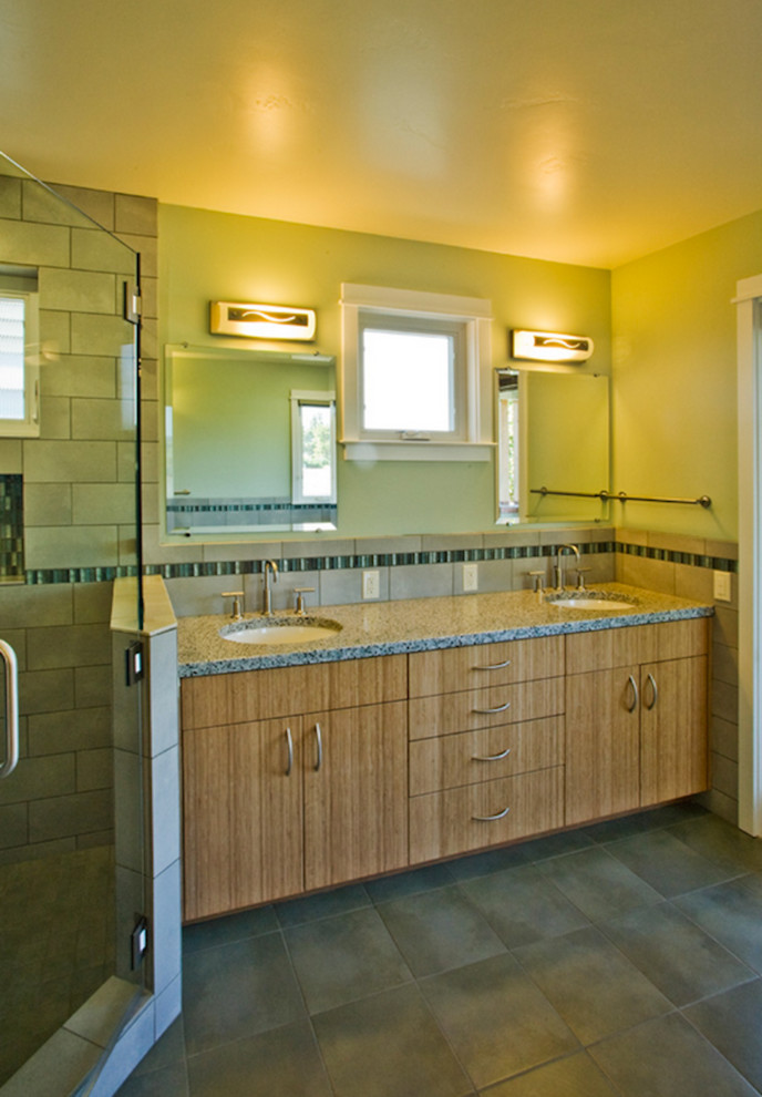Exemple d'une salle de bain principale chic en bois brun de taille moyenne avec un placard à porte plane, un plan de toilette en granite, une douche d'angle, un carrelage gris, des carreaux de céramique, un mur vert et un sol en carrelage de céramique.
