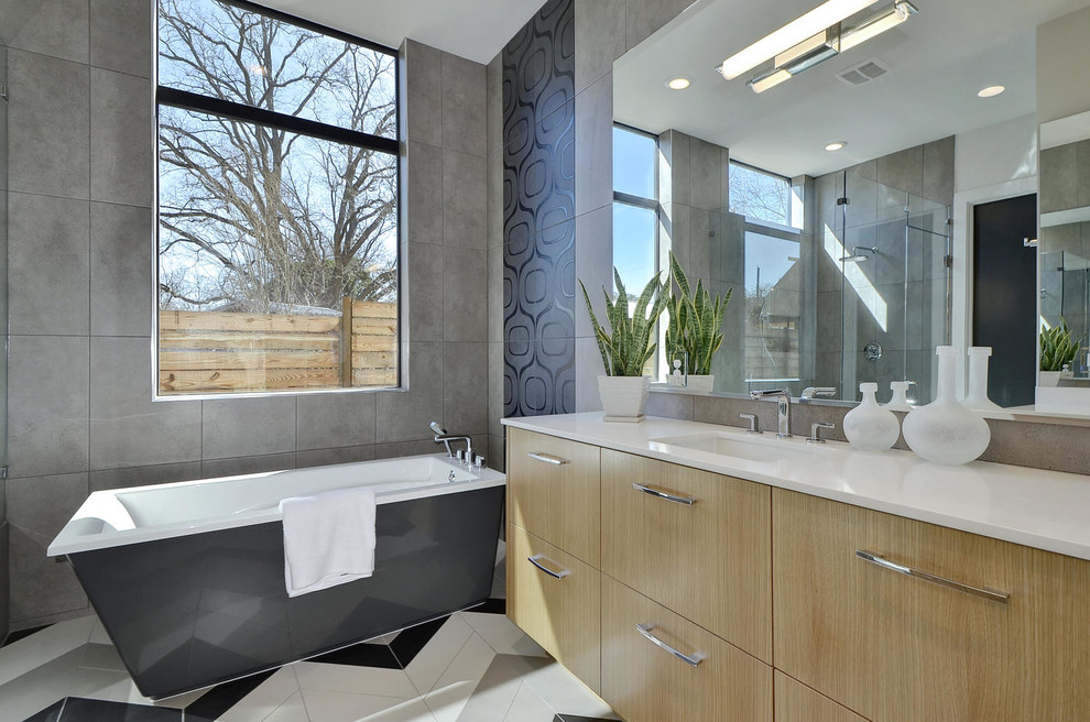 Inredning av ett modernt vit vitt en-suite badrum, med släta luckor, skåp i ljust trä, ett fristående badkar, grå kakel, grå väggar, ett undermonterad handfat och flerfärgat golv