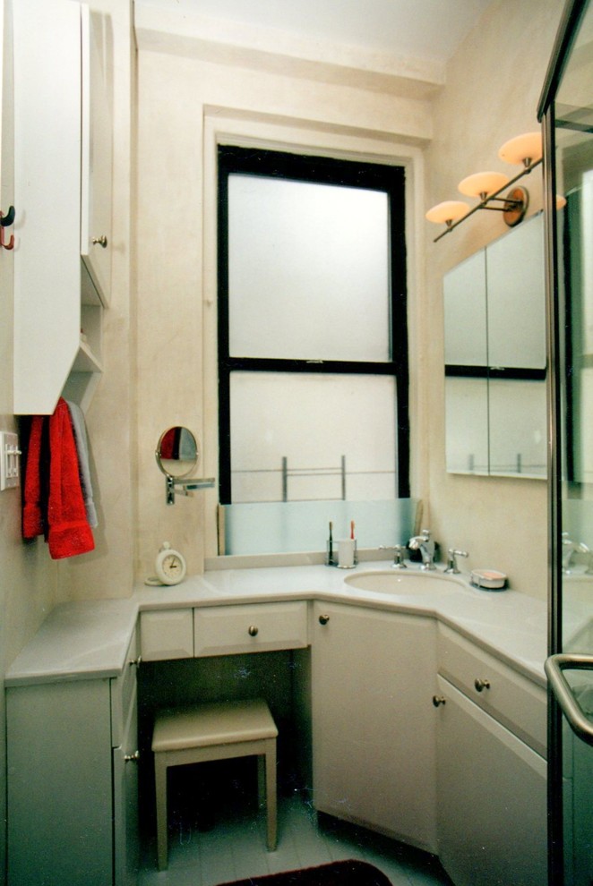 Réalisation d'une petite salle d'eau minimaliste avec un placard à porte plane, des portes de placard blanches, une douche d'angle, WC séparés, un mur blanc, un sol en carrelage de porcelaine, un lavabo encastré et un plan de toilette en surface solide.