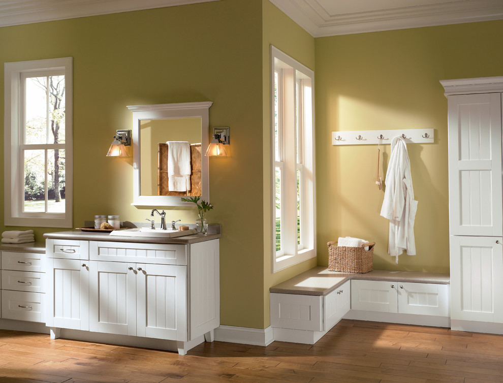 Klassisches Badezimmer mit Einbauwaschbecken, Kassettenfronten, weißen Schränken und grüner Wandfarbe in Sonstige