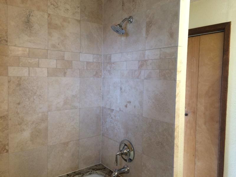 Idee per una stanza da bagno classica con top in granito, vasca sottopiano, piastrelle beige e piastrelle in pietra