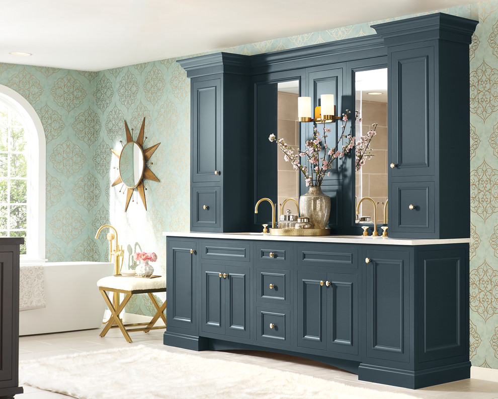 Diseño de cuarto de baño tradicional grande con puertas de armario azules, bañera exenta y encimeras blancas