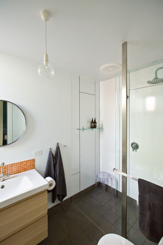 Kleines Modernes Badezimmer En Suite mit integriertem Waschbecken, hellen Holzschränken, Mineralwerkstoff-Waschtisch, offener Dusche, Toilette mit Aufsatzspülkasten, orangen Fliesen, Glasfliesen, weißer Wandfarbe, Porzellan-Bodenfliesen und flächenbündigen Schrankfronten in Melbourne