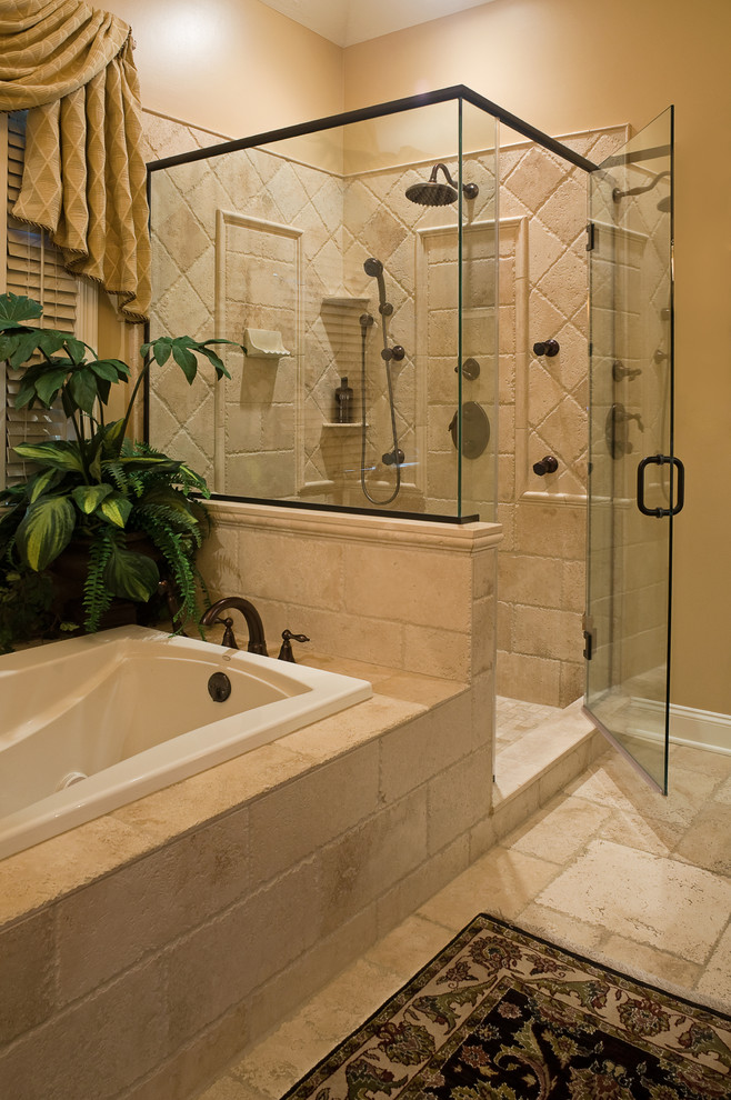 Aménagement d'une salle de bain principale classique en bois foncé avec un lavabo encastré, un placard avec porte à panneau surélevé, un plan de toilette en marbre, une baignoire posée, une douche d'angle, un carrelage beige, un carrelage de pierre et un sol en travertin.