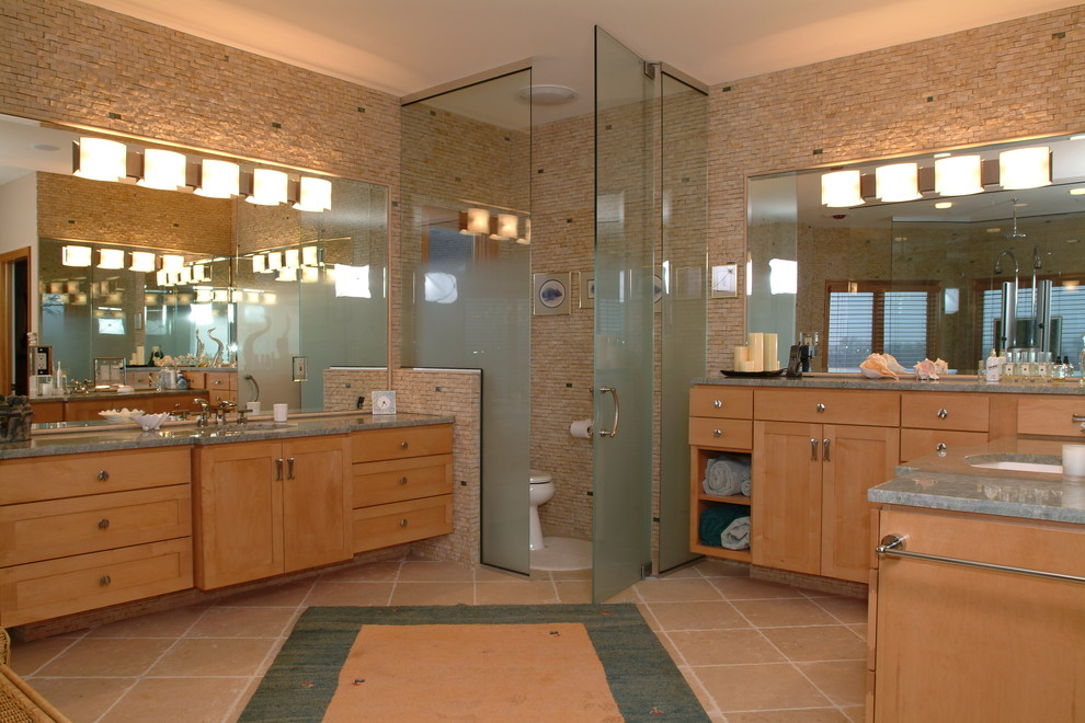 Réalisation d'une grande salle de bain principale tradition en bois clair avec un placard à porte shaker, WC à poser, un carrelage beige, un carrelage de pierre, un mur beige, un sol en carrelage de céramique, un lavabo encastré, un plan de toilette en granite et un sol beige.