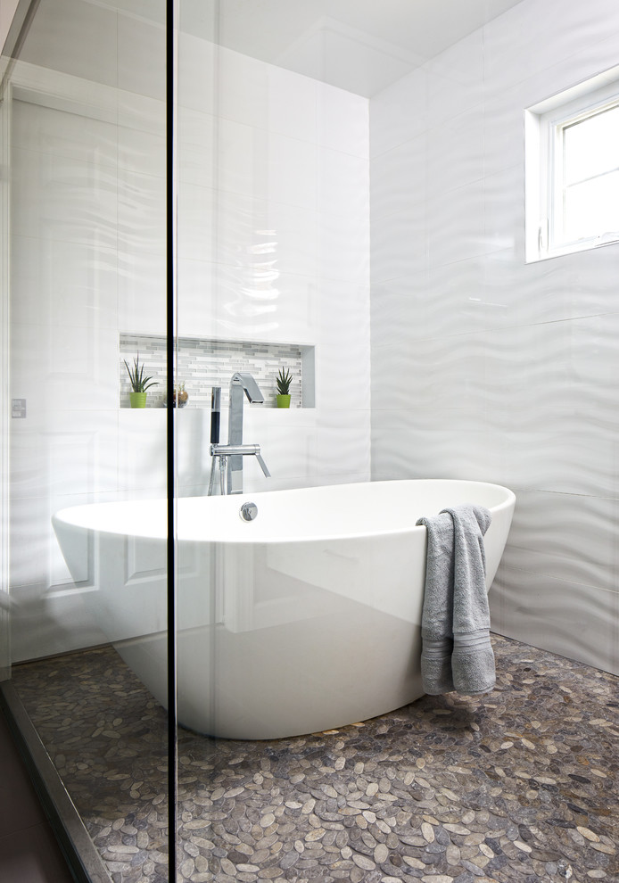 This is an example of a medium sized modern ensuite wet room bathroom in Chicago with flat-panel cabinets, white cabinets, a freestanding bath, a one-piece toilet, white tiles, ceramic tiles, grey walls, porcelain flooring, a submerged sink, engineered stone worktops, grey floors, a sliding door and grey worktops.