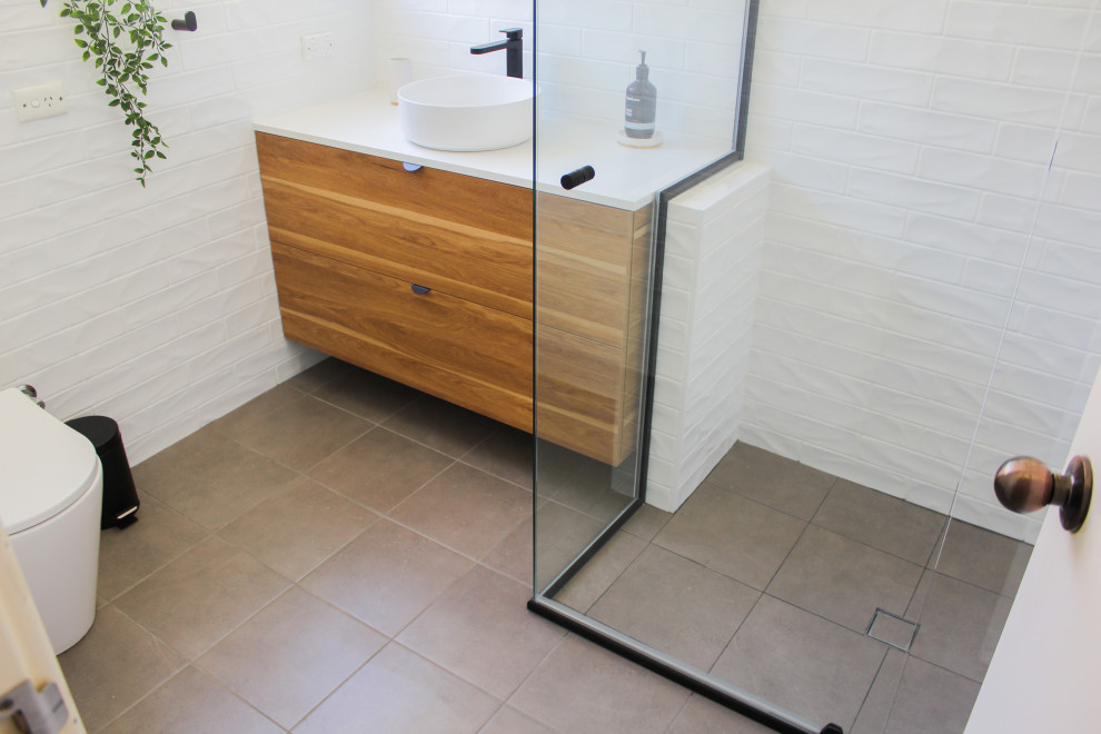 Design ideas for a small modern shower room bathroom in Perth with flat-panel cabinets, dark wood cabinets, a corner shower, a one-piece toilet, white tiles, metro tiles, white walls, porcelain flooring, a submerged sink, engineered stone worktops, grey floors, a hinged door and white worktops.