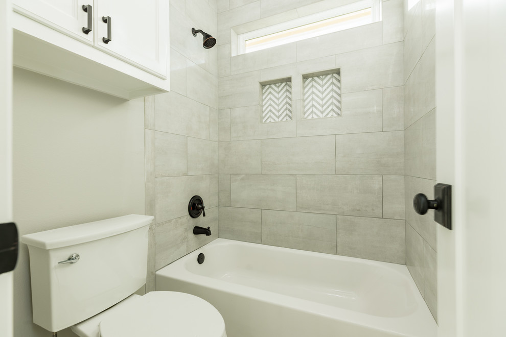 Идея дизайна: большая детская ванная комната в стиле кантри с фасадами с утопленной филенкой, серыми фасадами, ванной в нише, душем над ванной, раздельным унитазом, серой плиткой, керамогранитной плиткой, серыми стенами, полом из керамогранита, врезной раковиной, столешницей из гранита, белым полом, шторкой для ванной и белой столешницей