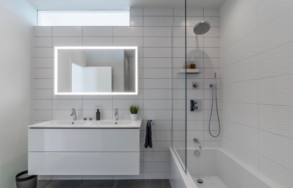 На фото: главная ванная комната в стиле модернизм с плоскими фасадами, белыми фасадами, угловой ванной, душем над ванной, инсталляцией, белой плиткой, керамогранитной плиткой, белыми стенами, полом из цементной плитки, серым полом, душем с распашными дверями и белой столешницей с