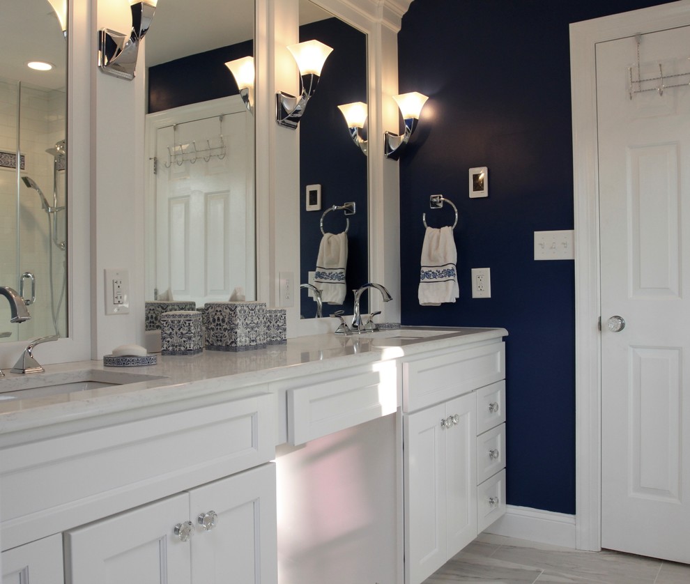 Mid-sized elegant master white tile and porcelain tile porcelain tile and gray floor bathroom photo with recessed-panel cabinets, white cabinets, a one-piece toilet, blue walls, an undermount sink, quartz countertops and a hinged shower door