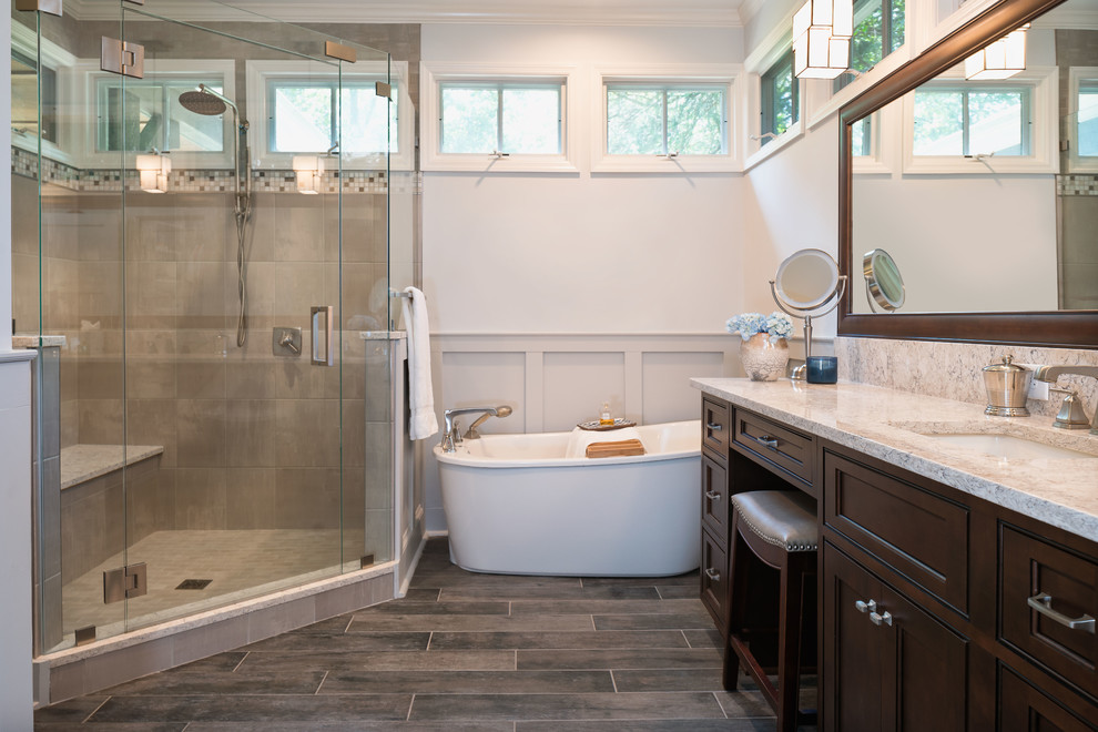 Cette image montre une salle de bain principale craftsman en bois foncé de taille moyenne avec un placard à porte affleurante, une baignoire indépendante, une douche d'angle, WC séparés, un carrelage gris, des carreaux de porcelaine, un mur bleu, un sol en carrelage de porcelaine, un lavabo encastré et un plan de toilette en quartz modifié.