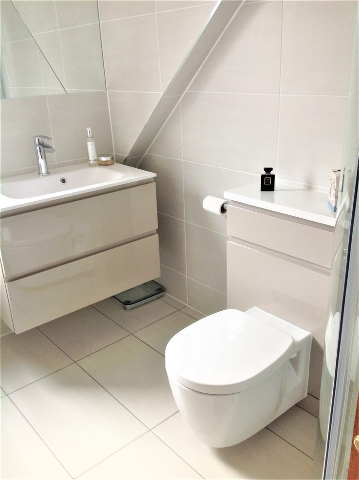 Photo of a contemporary family bathroom in Other with flat-panel cabinets, grey cabinets, a corner shower, beige tiles, ceramic tiles, ceramic flooring, a wall-mounted sink, beige floors and a sliding door.