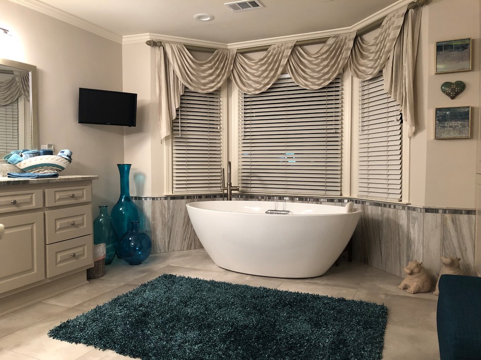 Design ideas for a large contemporary ensuite bathroom in Atlanta with raised-panel cabinets, grey cabinets, a freestanding bath, an alcove shower, grey tiles, marble tiles, grey walls, porcelain flooring, a submerged sink, granite worktops, grey floors, a hinged door and multi-coloured worktops.