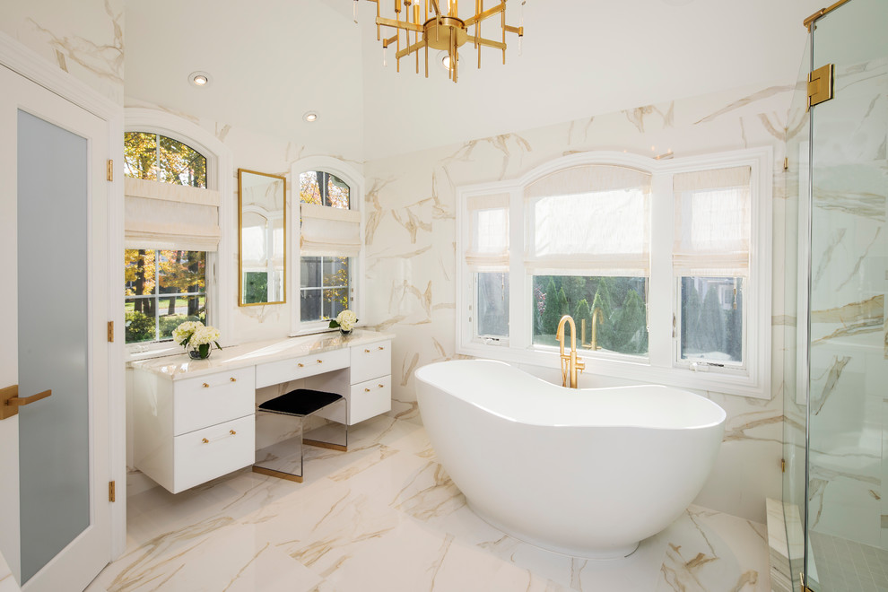 Foto på ett stort funkis vit en-suite badrum, med släta luckor, vita skåp, ett fristående badkar, en hörndusch, vit kakel, marmorkakel, vita väggar, marmorgolv, marmorbänkskiva, vitt golv och dusch med gångjärnsdörr