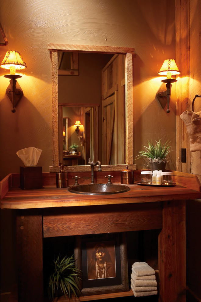 Modelo de cuarto de baño de estilo americano con suelo de madera oscura, armarios abiertos, puertas de armario de madera en tonos medios, lavabo encastrado, encimera de madera, paredes beige y aseo y ducha