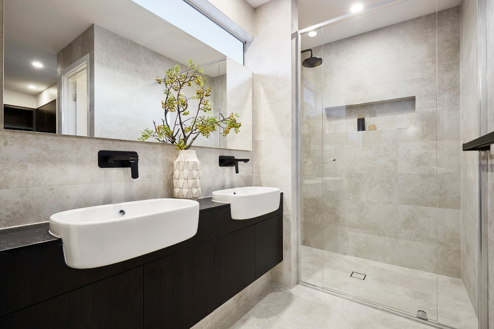 Réalisation d'une salle de bain design avec un placard à porte plane, des portes de placard noires, un mur gris, un lavabo posé, un sol gris et une cabine de douche à porte battante.