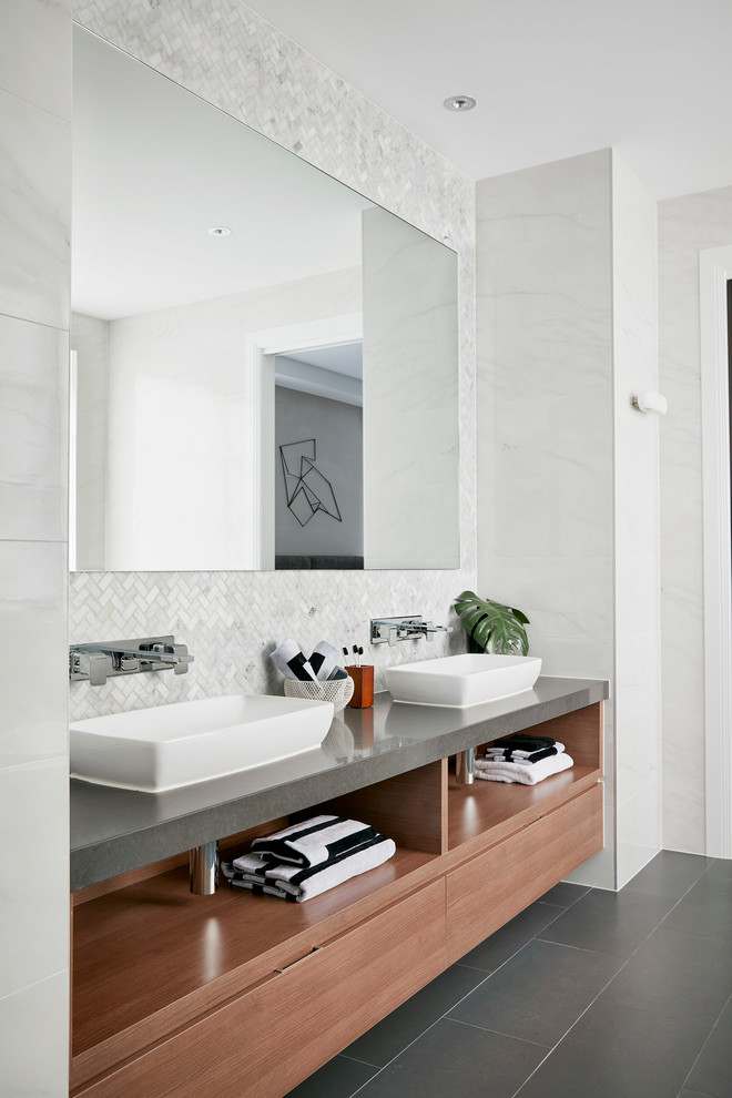 Ejemplo de cuarto de baño actual grande con baldosas y/o azulejos grises, lavabo sobreencimera, puertas de armario de madera oscura y paredes blancas
