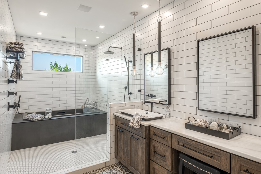Exemple d'une salle de bain chic en bois foncé avec un placard avec porte à panneau encastré, une baignoire posée, un espace douche bain, un carrelage blanc, un carrelage métro, une vasque, un sol multicolore et un plan de toilette blanc.