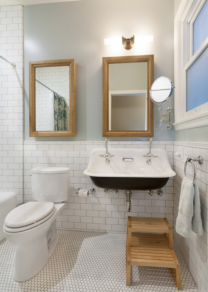Bild på ett litet vintage badrum, med ett avlångt handfat, ett badkar i en alkov, en dusch/badkar-kombination, en toalettstol med separat cisternkåpa, vit kakel, keramikplattor, grå väggar och klinkergolv i keramik